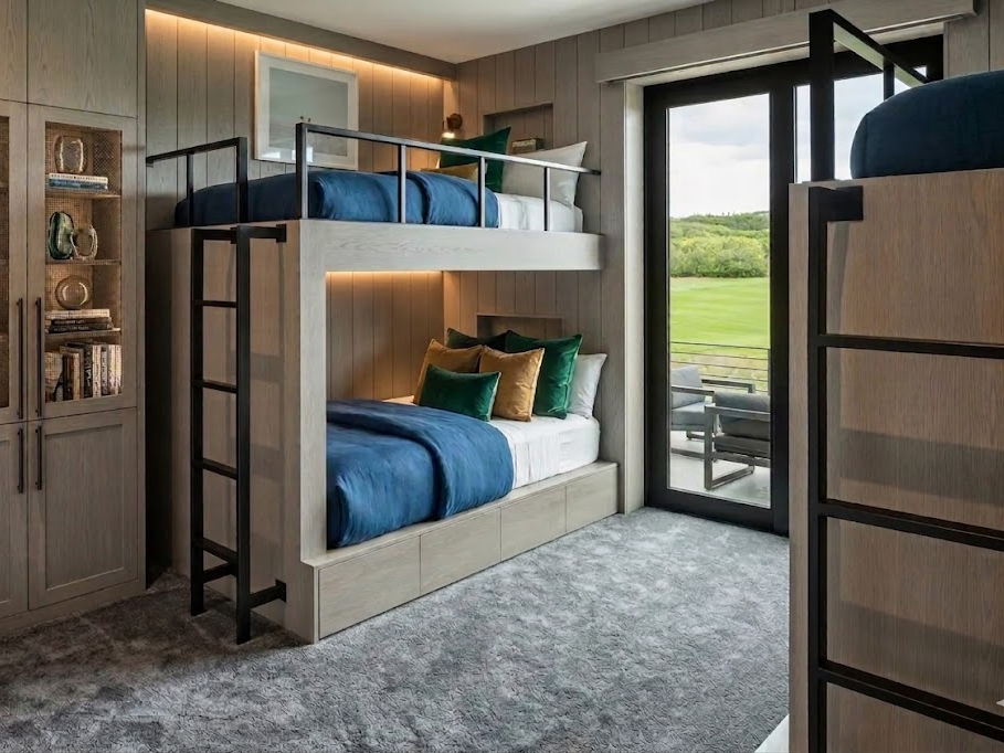 Installed bunk room with integrated storage, wall paneling, and black metal ladder