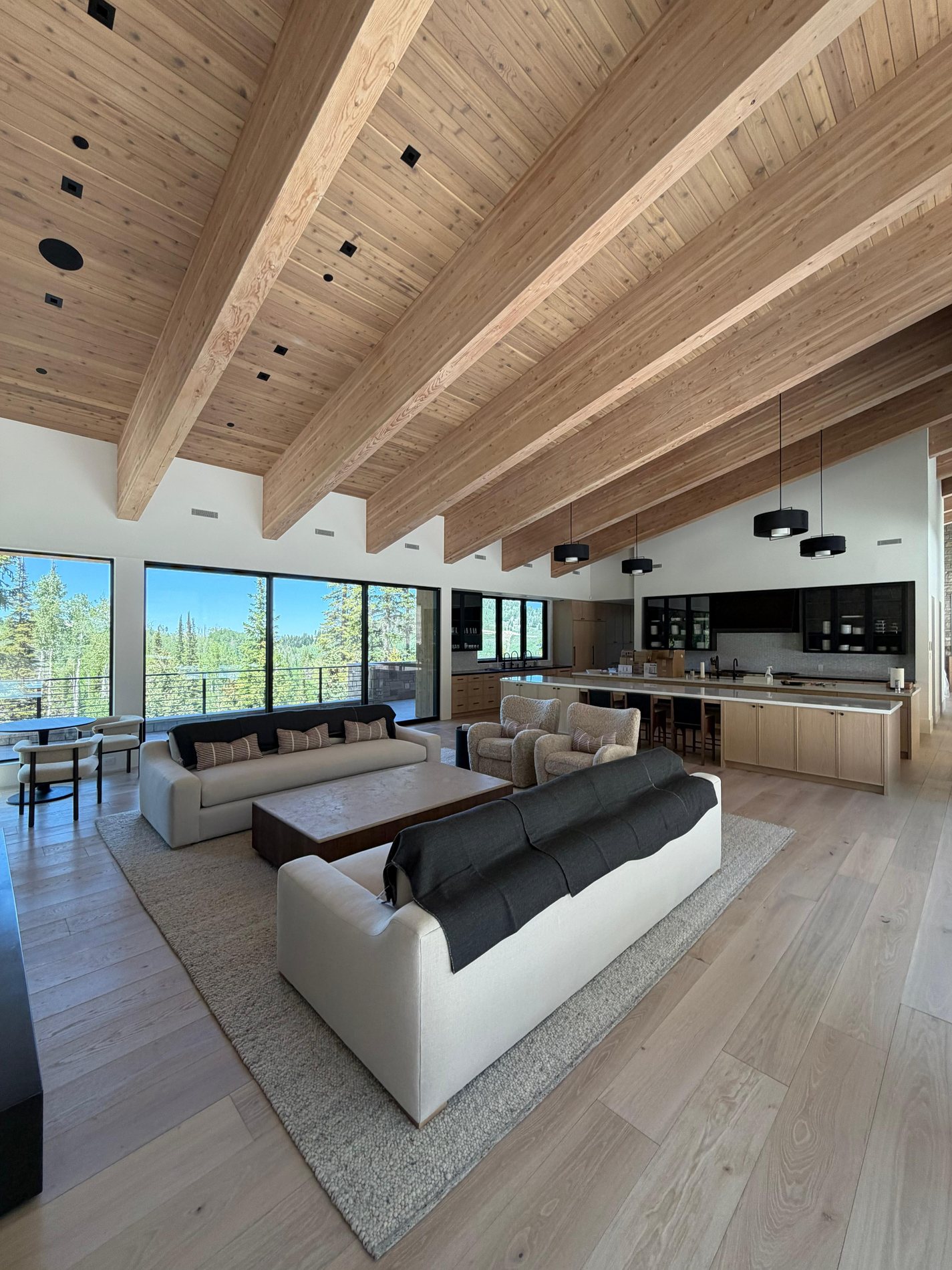 Finished great room and kitchen with cedar ceiling, timber beams, and custom interior carpentry at The Colony