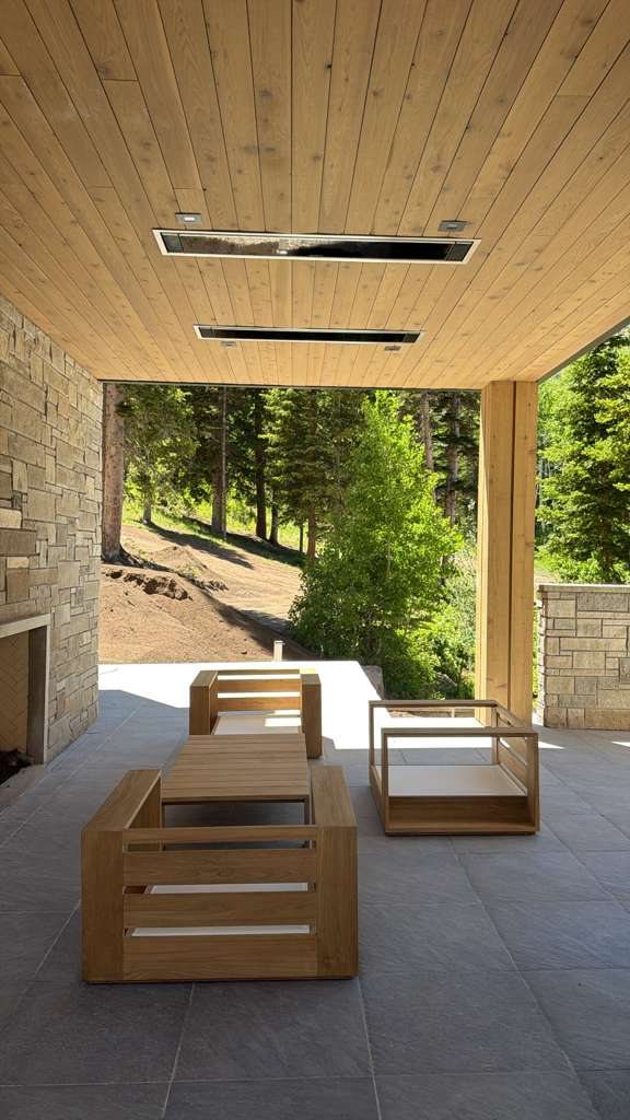 Finished covered outdoor living area with wood ceiling and mountain residence detailing